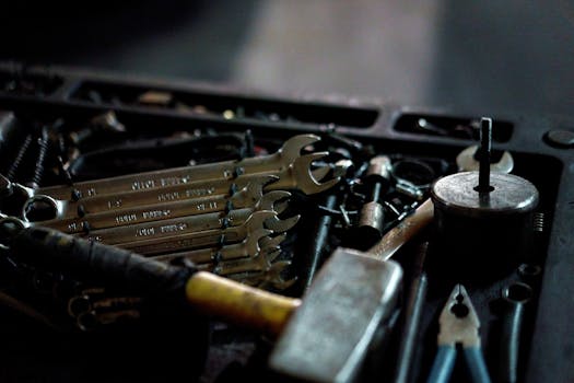A collection of hand tools including wrenches and a hammer in a toolbox, suitable for repair work.