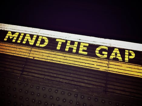 Bold 'Mind the Gap' text on a subway platform, emphasizing passenger safety.